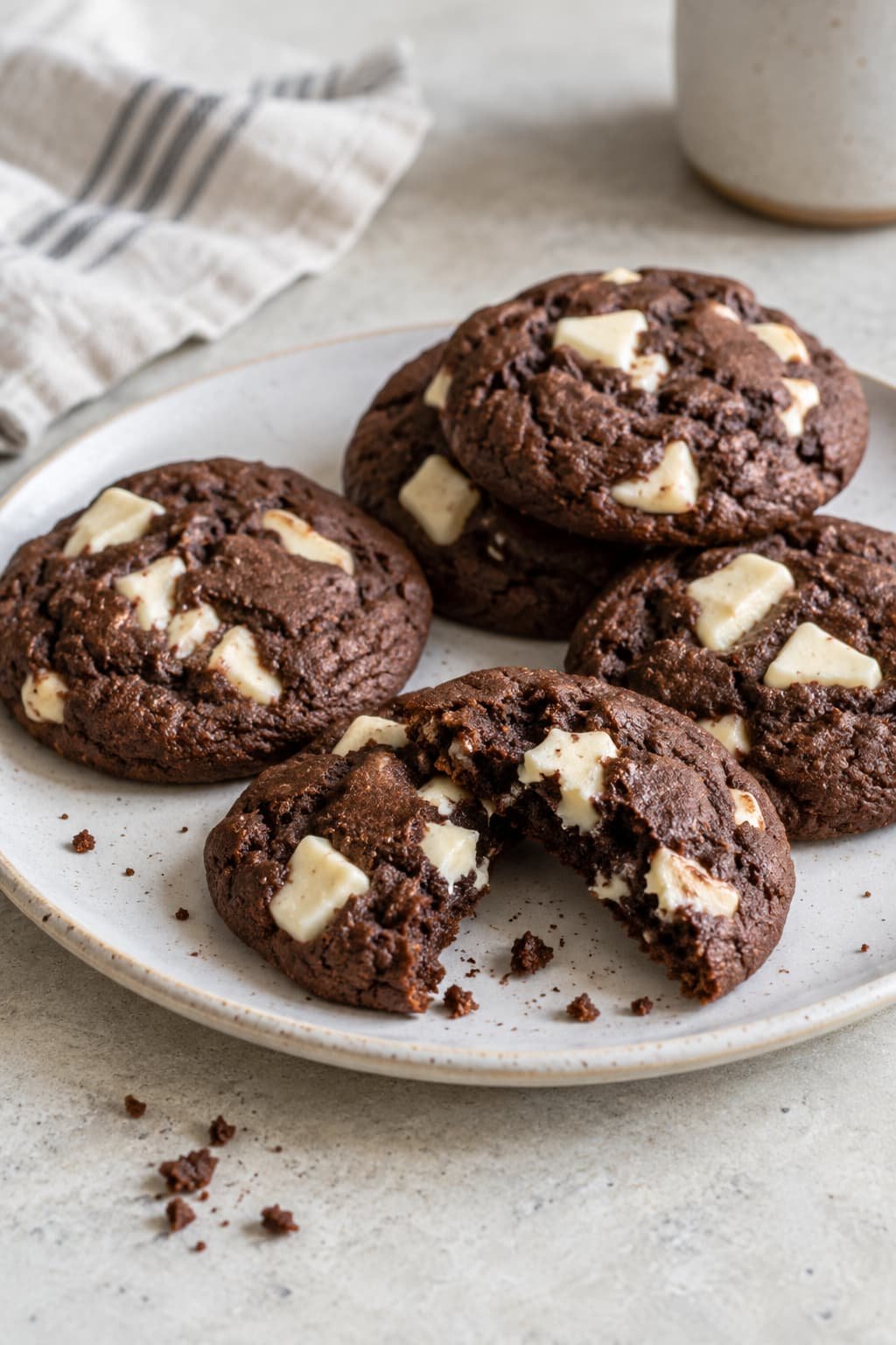 Cocoa-based chocolate cookies with white chocolate pieces on a neutral surface
