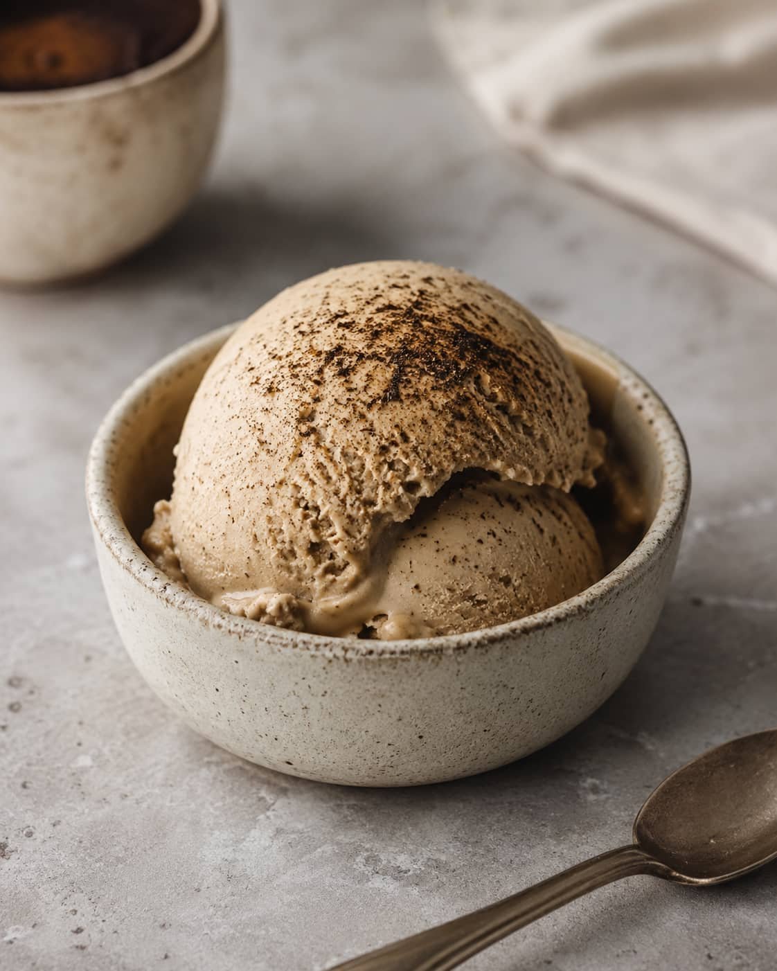 Hojicha ice cream served in a small ceramic bowl on a neutral surface